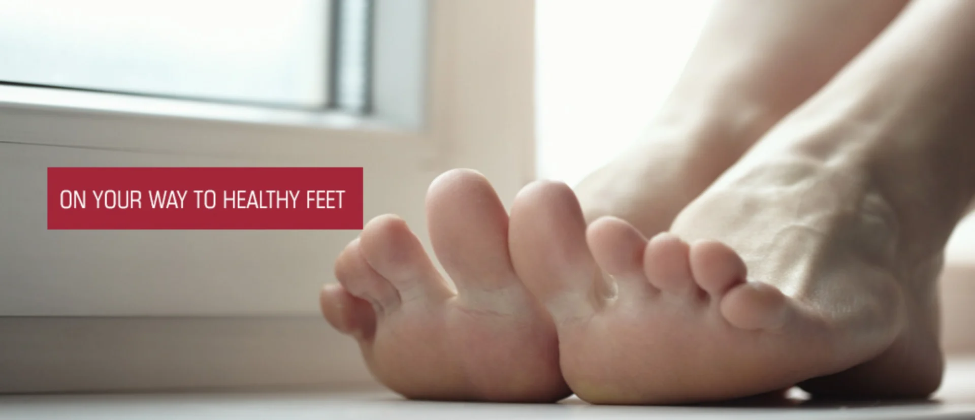 Person's legs on the floor with a window in the background